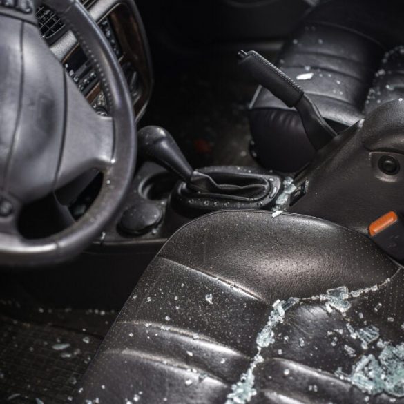 vandalized car with glass on driver seat