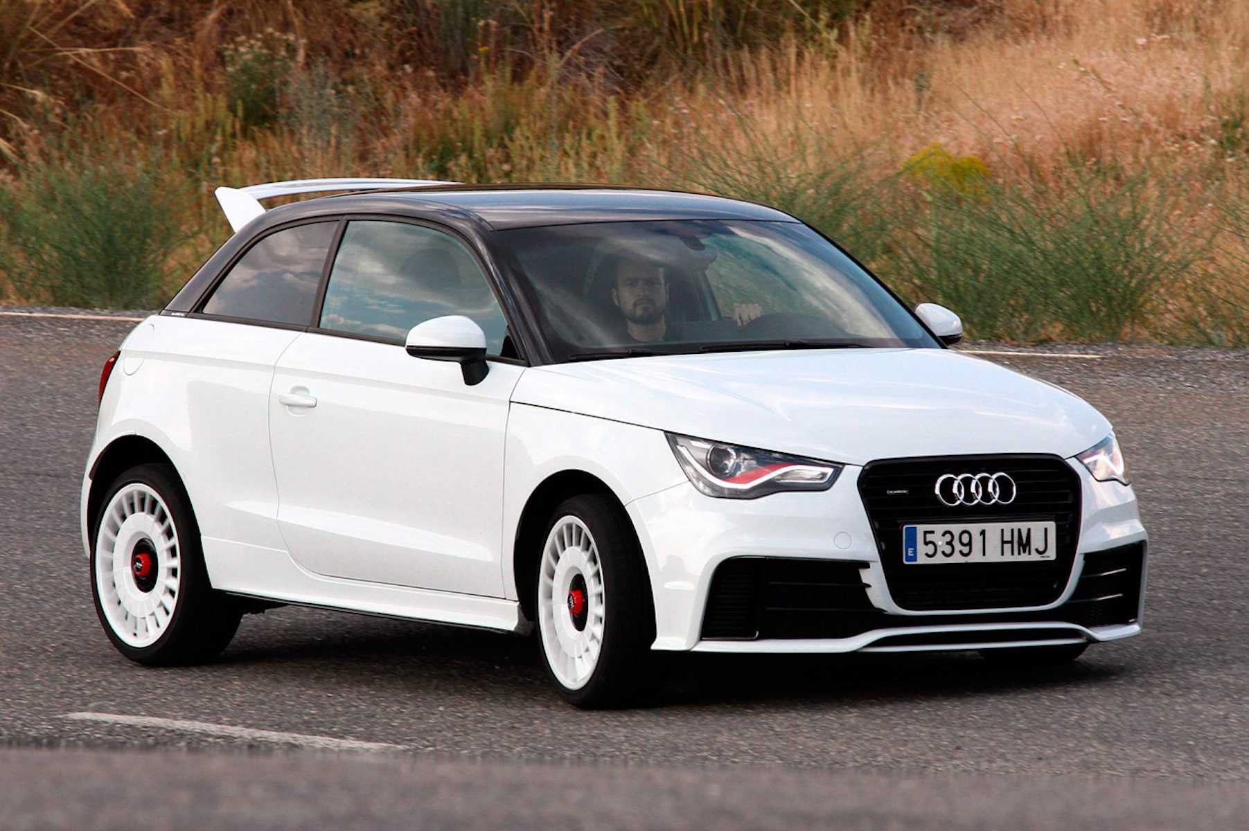 A side view of a driver enjoying his ride in the 2011 White Audi A1 Quattro Coupe