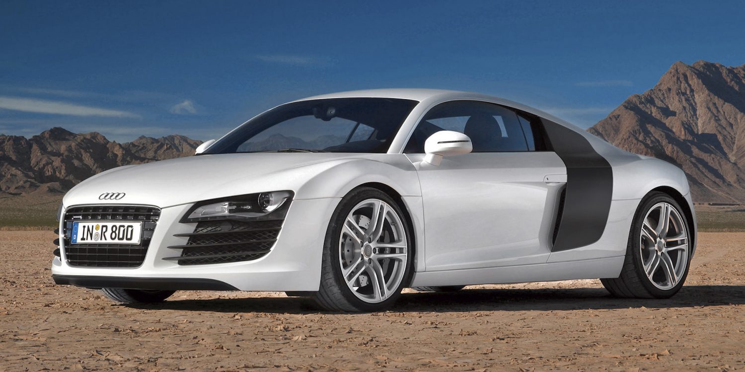 A side view of a white First Gen Audi R8 in a desert
