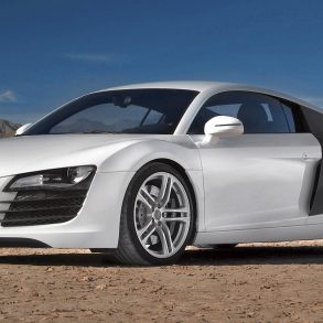 A side view of a white First Gen Audi R8 in a desert