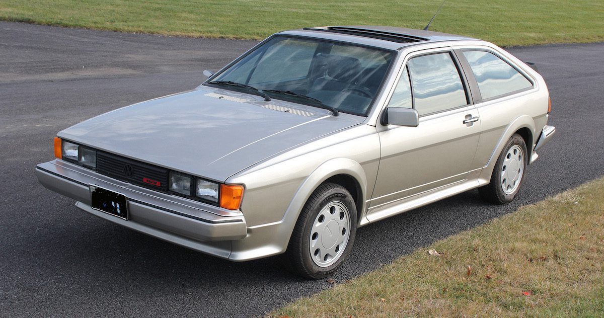 A side view of a Second-gen 16V silver VW Scirocco on a black asphalt road