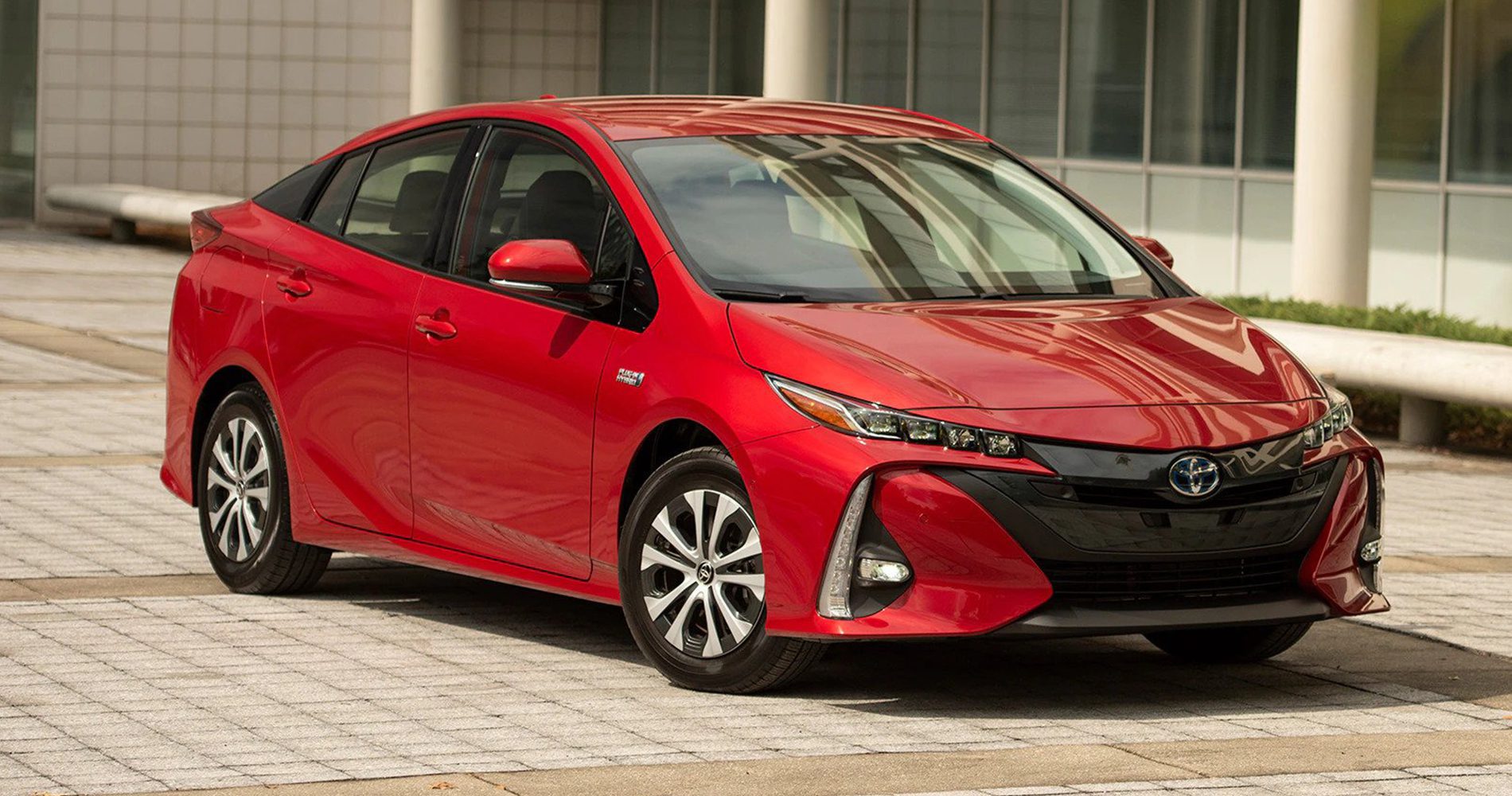 2022 red Toyota Prius hybrid sedan on city setting