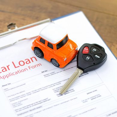 Toy car and keys on car loan document