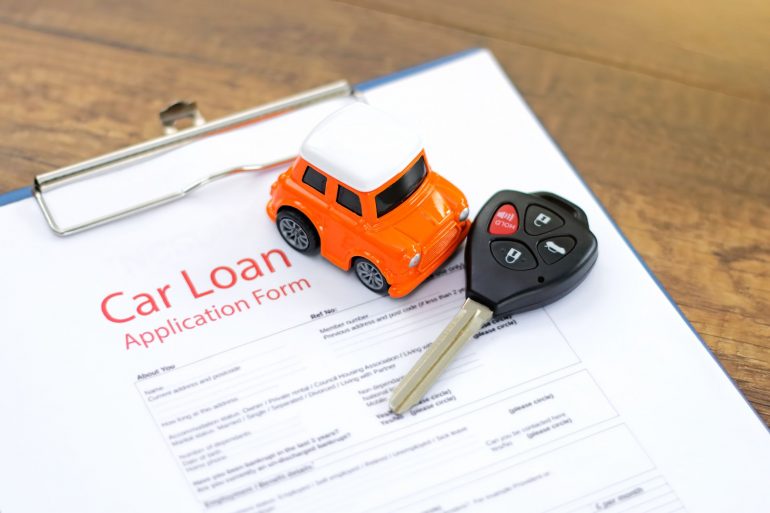 Toy car and keys on car loan document