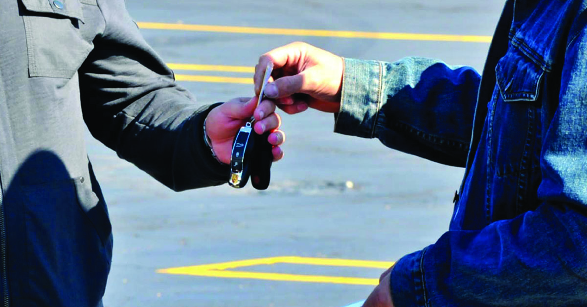 Handing off car keys to the auto transport driver