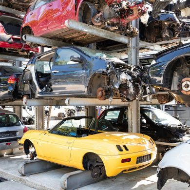 various cars at a junkyard with parts removed