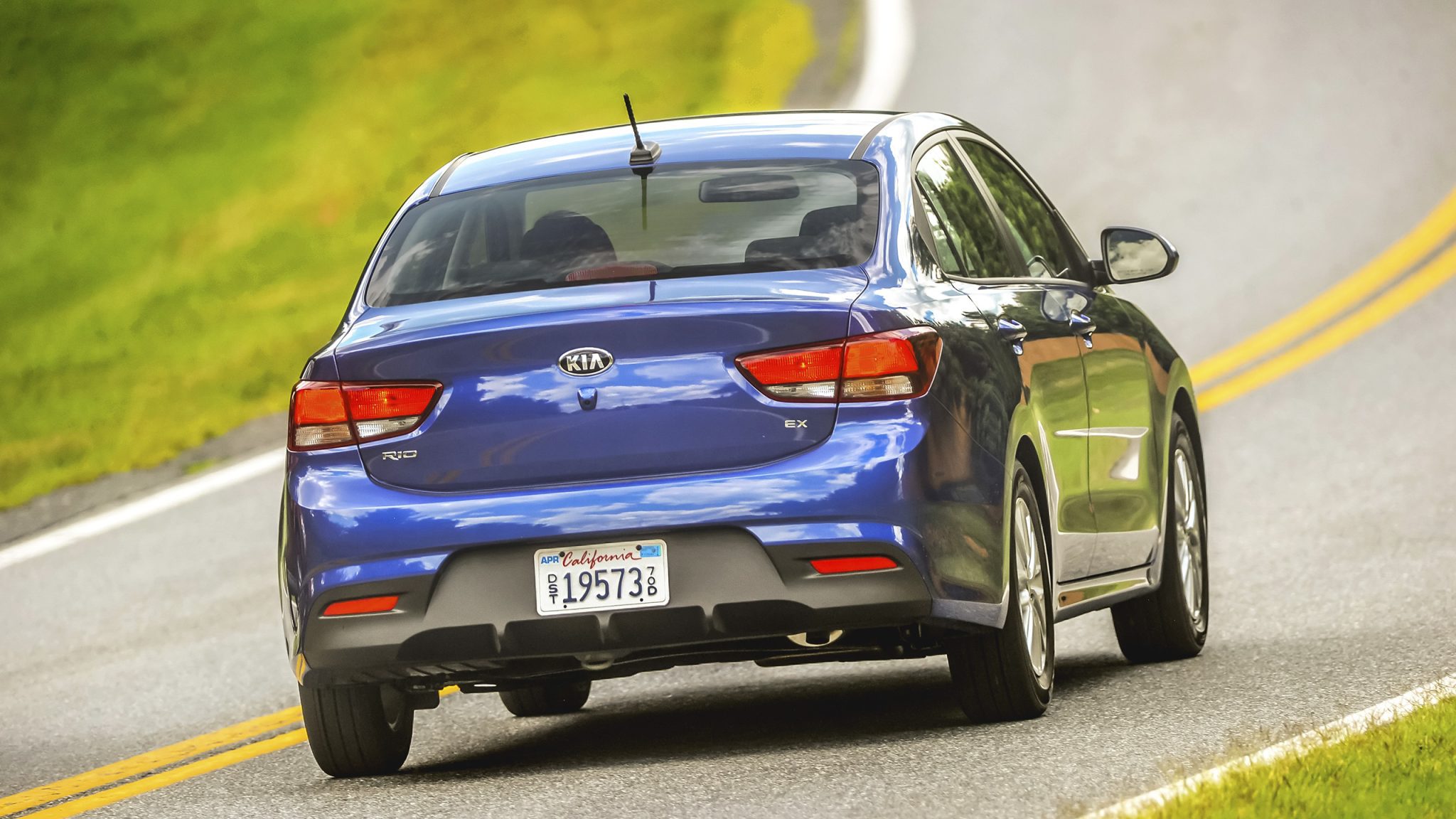 Rear view of a 2023 blue Kia Rio sedan