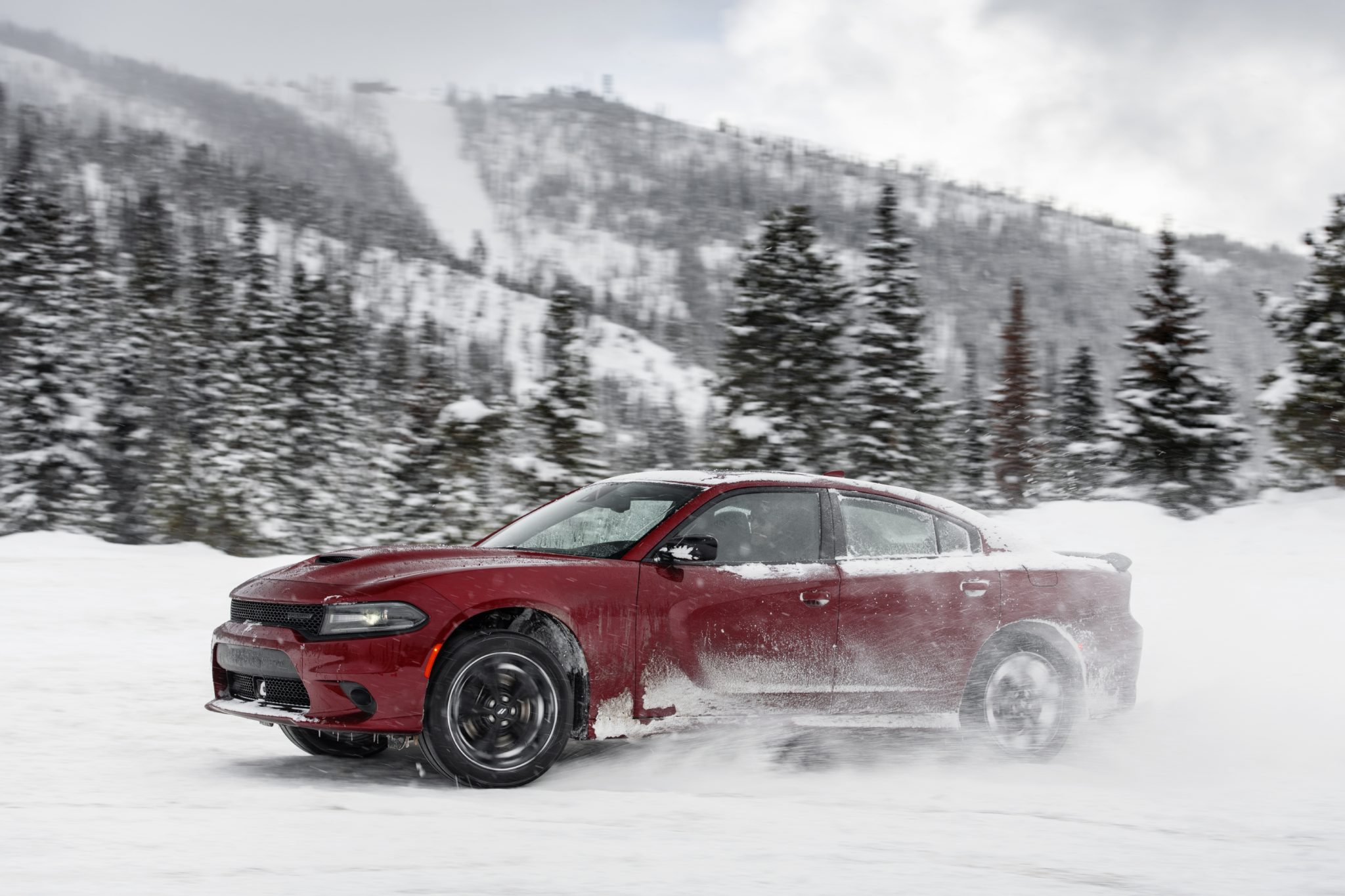 Side angle of a 2023 red Dodge Charger GT AWD on snow