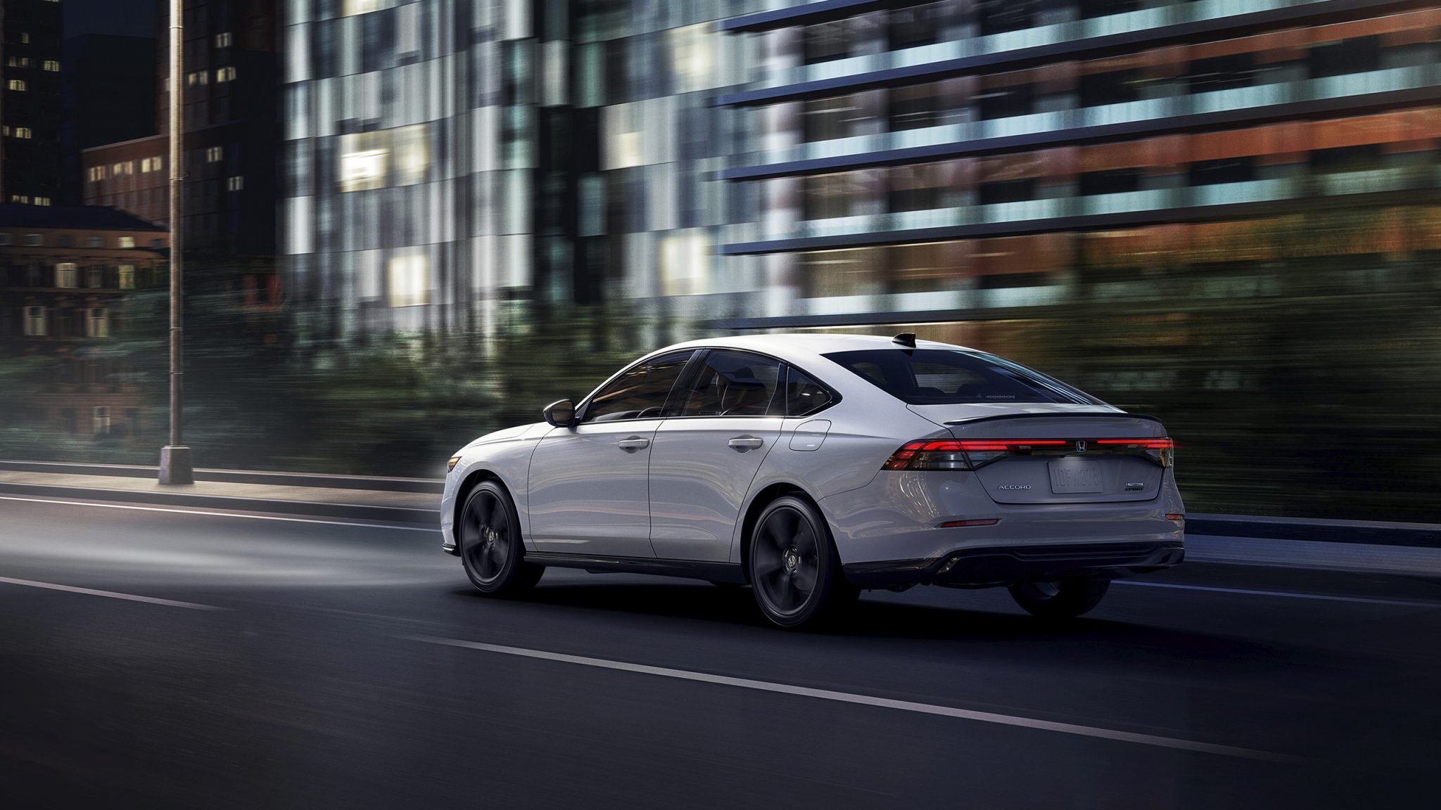Three-quarter rear view of a 2023 white Honda Accord Hybrid