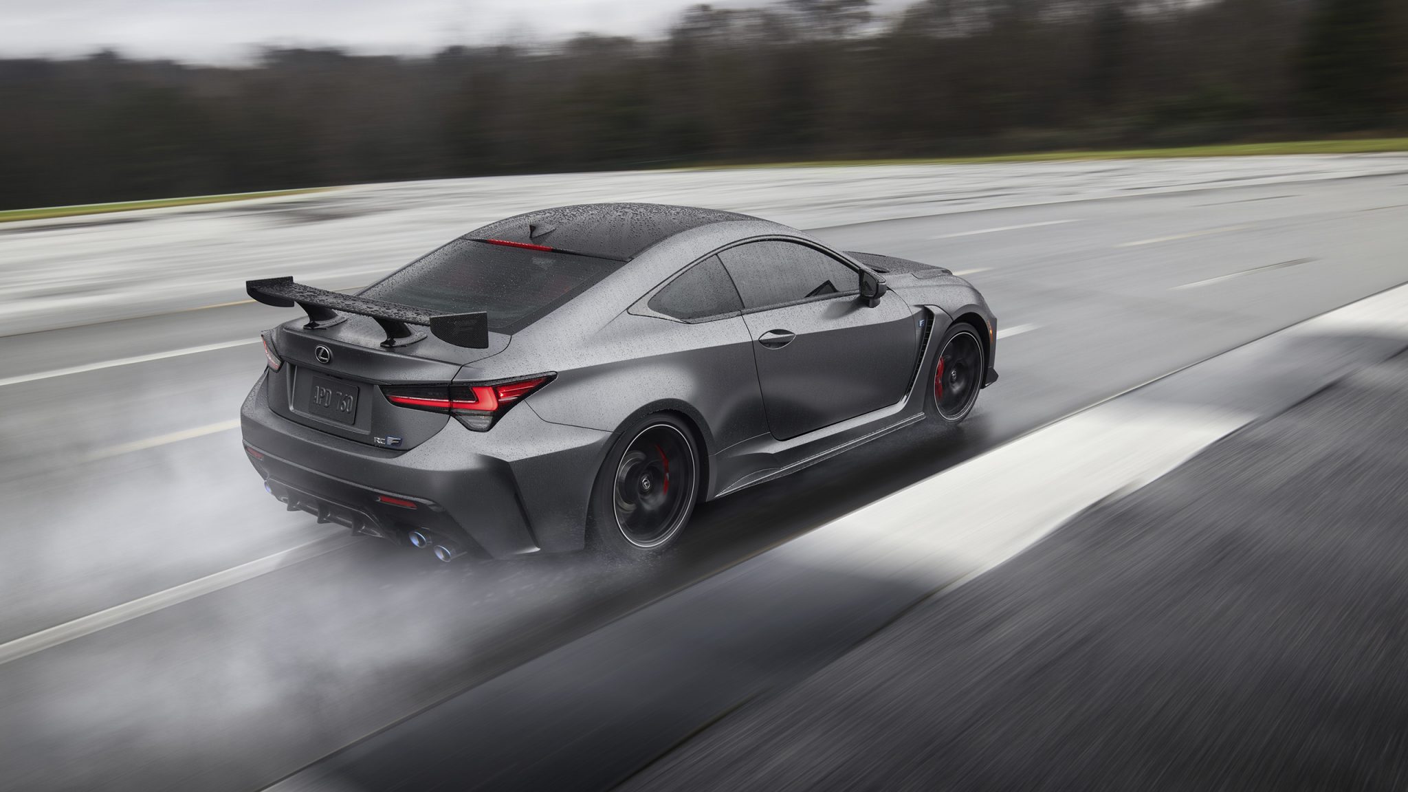 Three-quarter side view of a 2023 grey Lexus RC F Track Edition on a wet track
