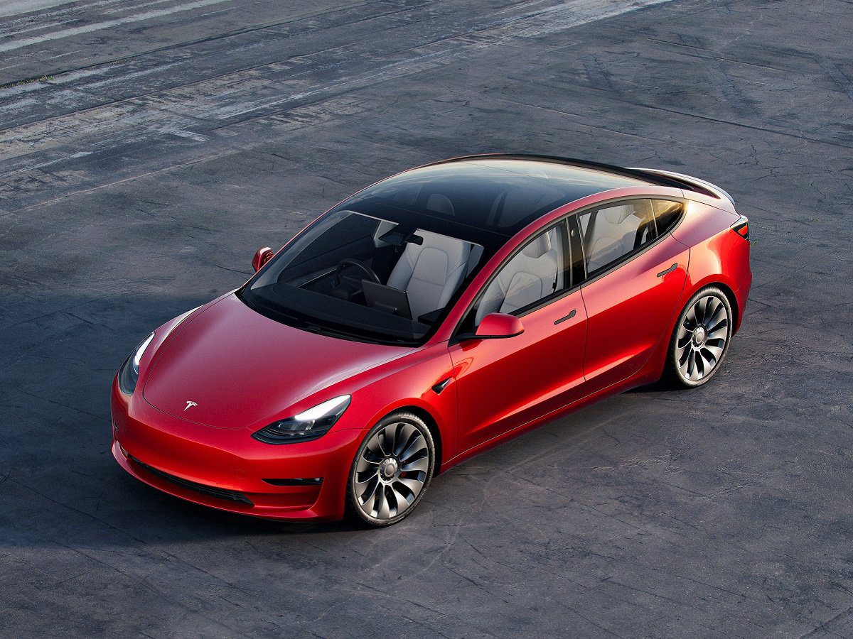 Angled aerial view of a red Tesla Model 3