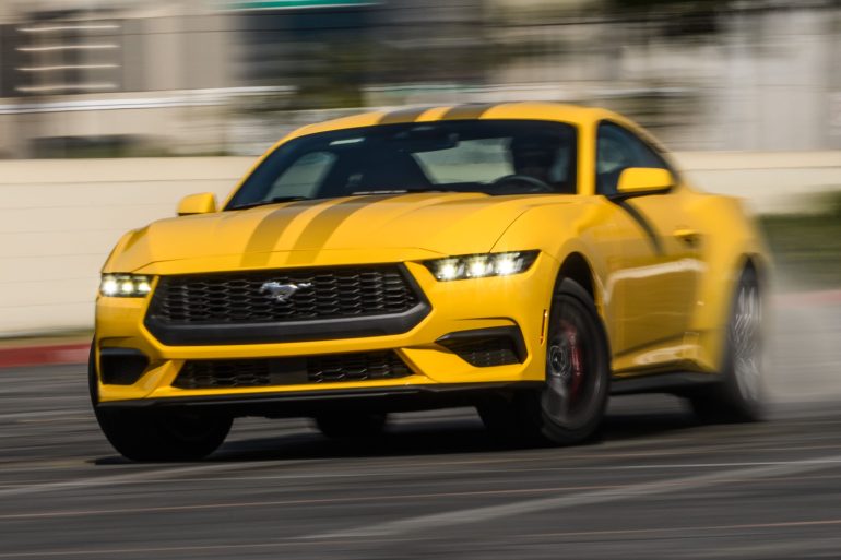 Front-angled view of a yellow Ford Mustang captured in a drift