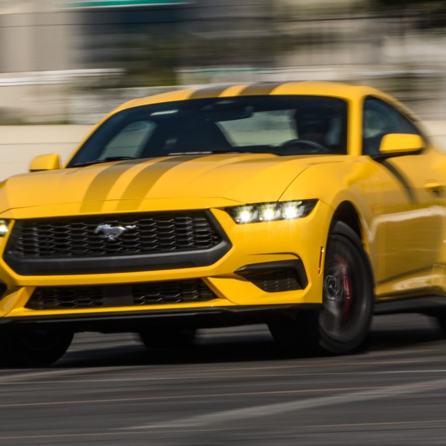 Front-angled view of a yellow Ford Mustang captured in a drift