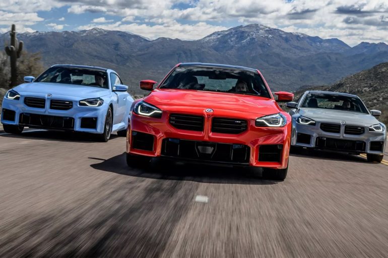 Frontal view of three 2024 BMW M2 coupes driving on a highway