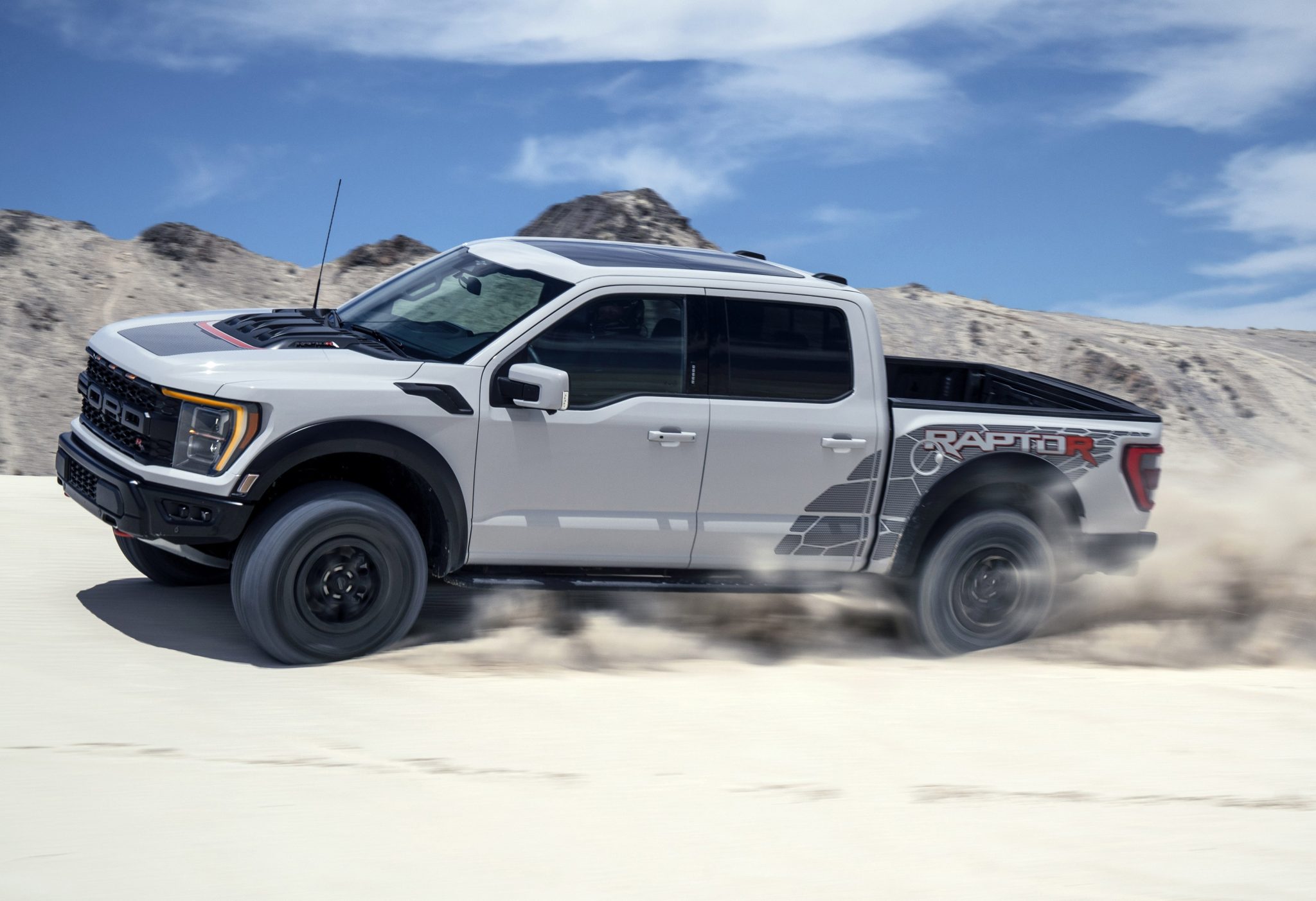 Side view of a 2024 white Ford Raptor R in a dune
