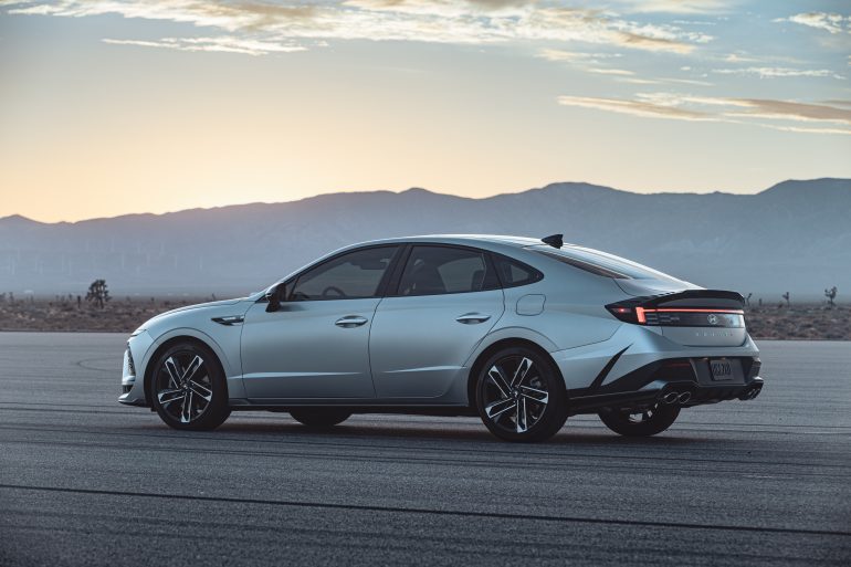 Three-quarter side view of a 2024 Hyundai Sonata N Line with mountain background