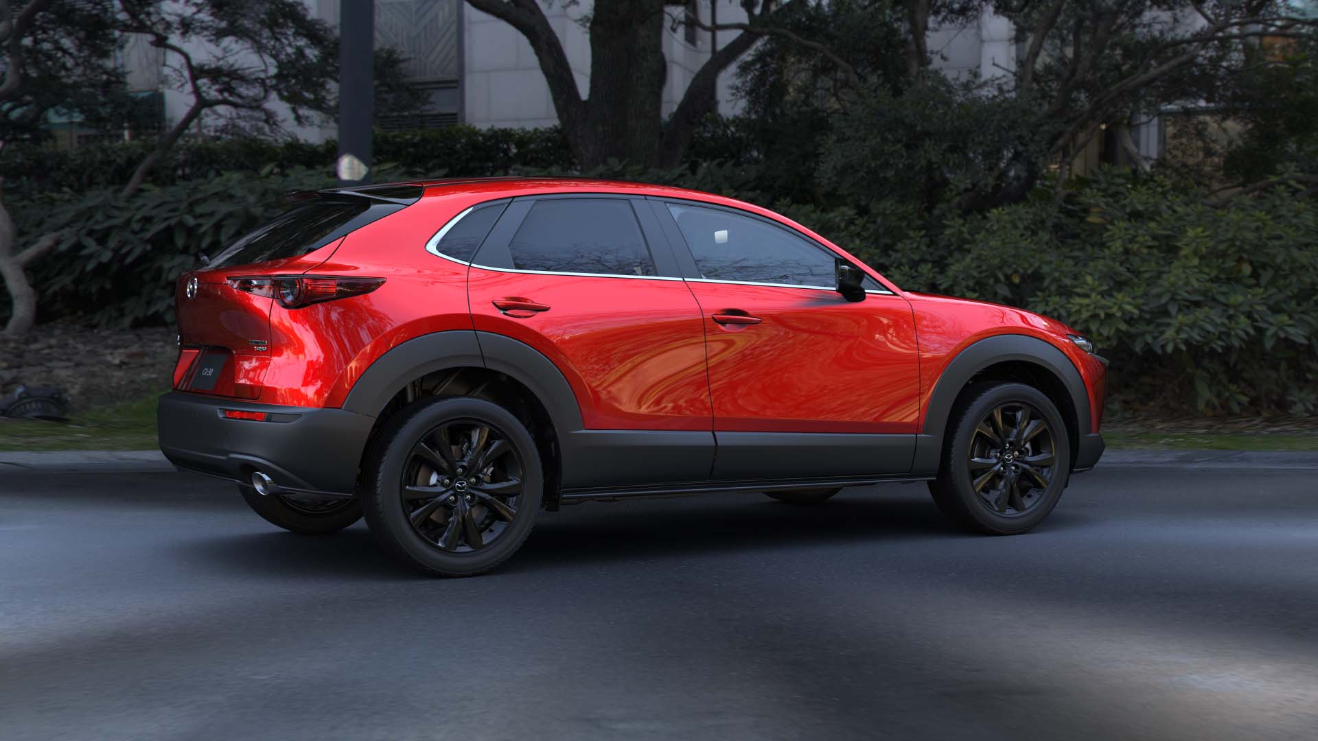 Side view of a 2024 red Mazda CX-30 on a city street