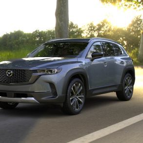 Three-quarter front view of a 2024 grey Mazda CX-50 with sunset background