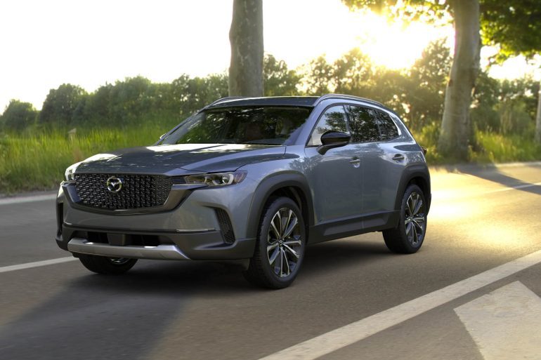 Three-quarter front view of a 2024 grey Mazda CX-50 with sunset background