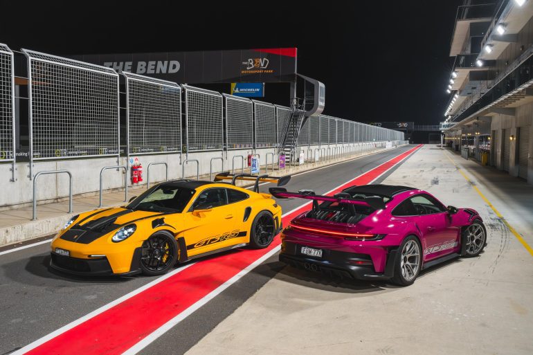 Image showing two 2024 Porsche 911 GT3 RS supercars, one in yellow and black and the other in purple.