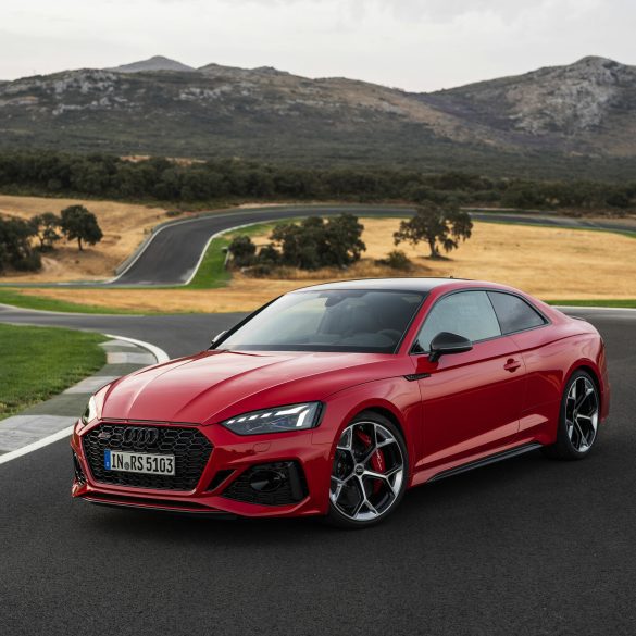 Three-quarter side view of a 2024 red Audi RS5 Sportback on a track