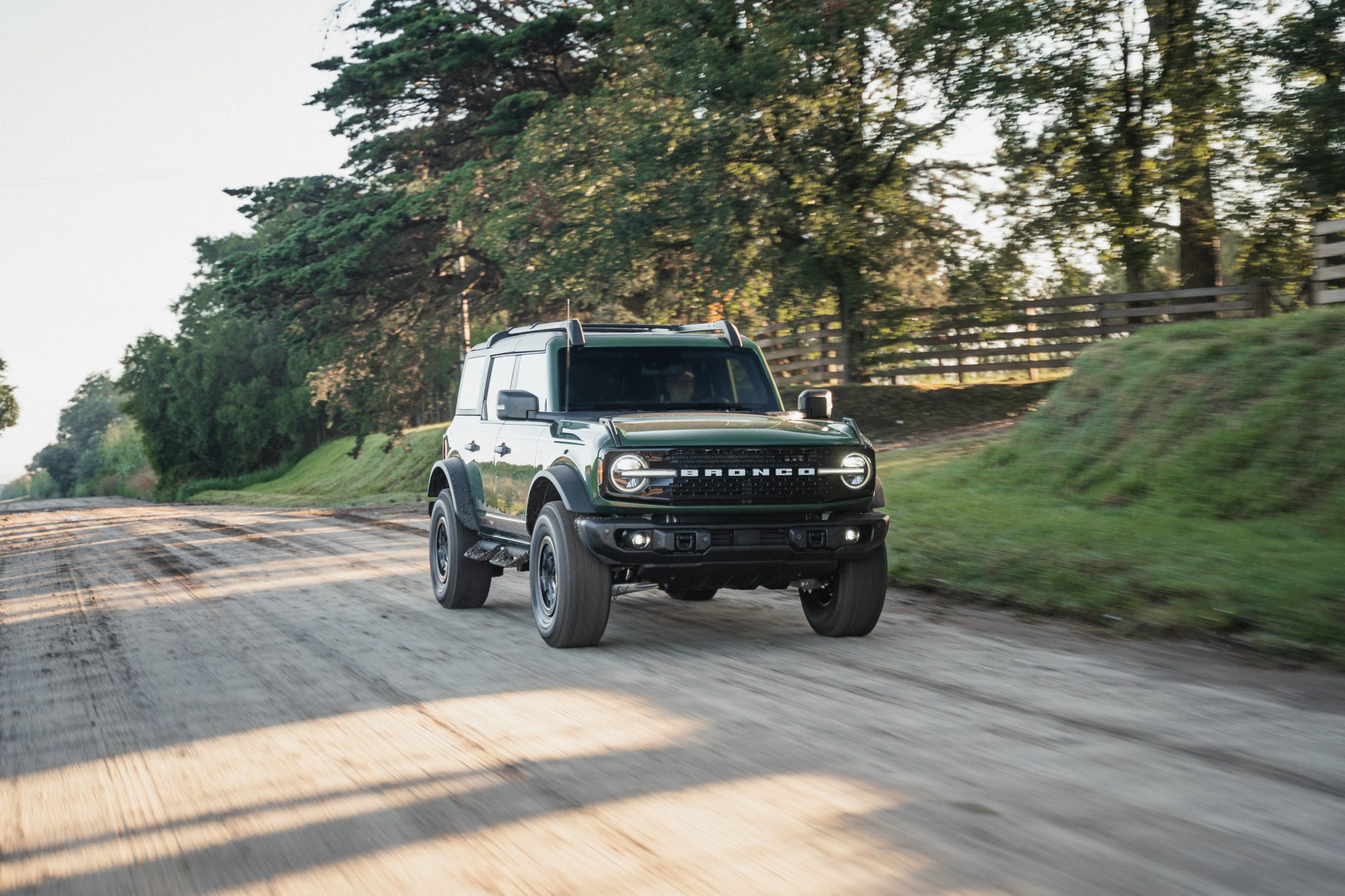 Front view of a 2024 green Ford on a dirt road