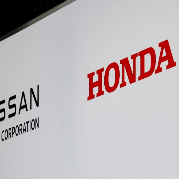 Photo of the a Nissan and Honda logos at a press conference about a potential merger.